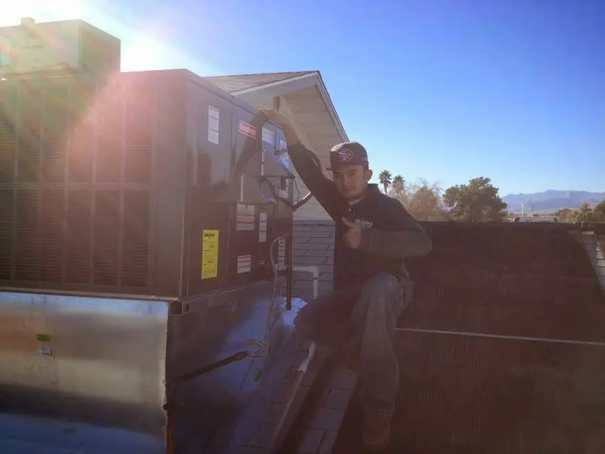 HVAC technician performing Boiler Repair on a rooftop unit in Solebury